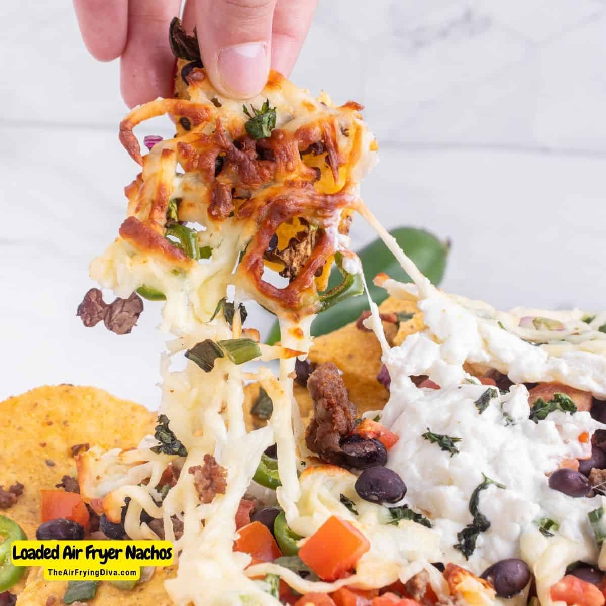 Loaded Air Fryer Nachos (with video), a quick and delicious meal or snack recipe featuring tortilla chips topped with gooey cheese and more.